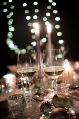christmas eve party table with wine glass and glitter season's greeting decoration