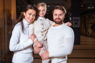 portrait of smiling parents and daughter looking at camera