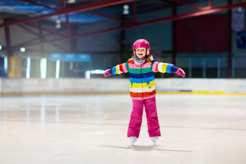 Child skating on indoor ice rink. Kids skate.