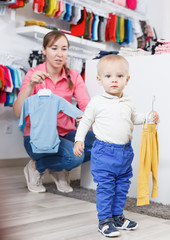 female with kid is looking clothes for son