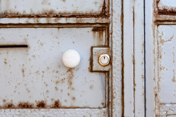 door handle and lock on an old rusty metal door. fence. the background.
