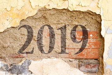 2019 new year painted on  Old Brick Wall Texture. Painted Distressed Wall Surface. Grungy Wide Brick wall. Grunge Red Stonewall Background. Shabby Building Facade With Damaged Plaster. 