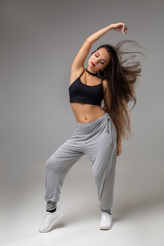 Modern style dancer posing on studio background. Hip hop, jazz funk, dancehall