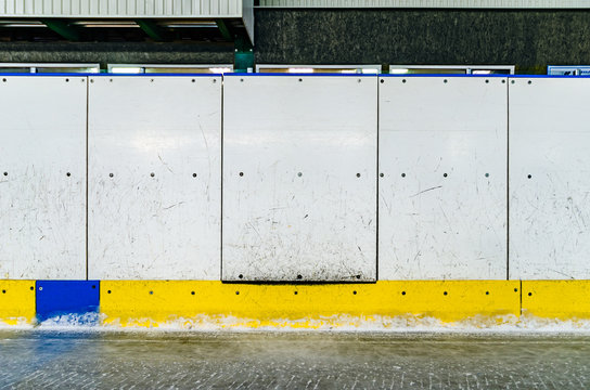 Hockey rink side boards with door and scratched and damaged surface
