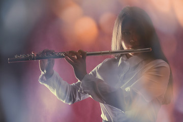 Young girl with flute, on dark background