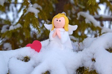 An angel on a snow-covered Christmas tree.Winter holiday.Christmas card.