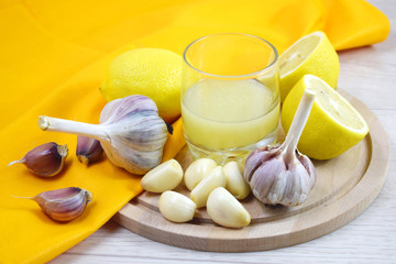 Fototapeta na wymiar Healthy lemon drink and fresh garlic.