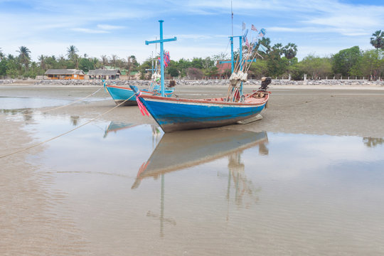 Wooden fishing boat on the  low tide beach
