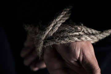 man with his hands tied behind his back