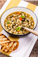 Traditional Italian-Style Wedding Soup. Made with Meatballs, Carrots and Spinach in Chicken Broth. Selective focus.