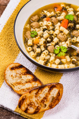 Traditional Italian-Style Wedding Soup. Made with Meatballs, Carrots and Spinach in Chicken Broth. Selective focus.