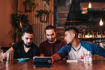 Group of arabian friends taking selfie in lounge bar. Mixed race young men having fun