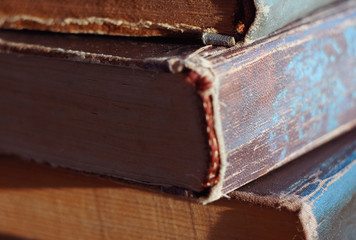 old battered thick books lying in a pile