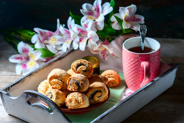 Homemade breakfast: rolls and cup of tea on vintage serving tray.