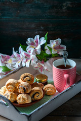 Homemade breakfast: rolls and cup of tea on vintage serving tray.