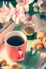 Homemade breakfast: rolls and cup of tea on vintage serving tray.