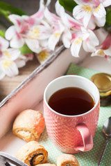 Homemade breakfast: rolls and cup of tea on vintage serving tray.