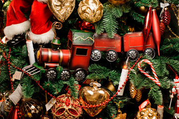 Background of fir tree with red toy train and christmas decoration