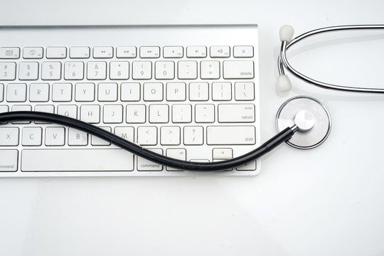 Adoption Of Technology In Healthcare Industry Concept. Stethoscope And Keyboard On White Background. Flat Lay Or Top View.  