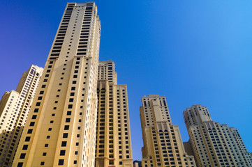 Fototapeta na wymiar Skyscrapers from below in Dubai against blue sky. Raising the bar.