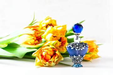 Luxurious perfume bottle with flowers on white background. Feminine beauty concept.