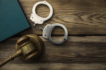 The judge gavel and handcuffs with book