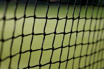 Close up of tennis net with an out of focus green background