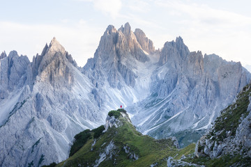 Man standing before stunning Mountains at sunet