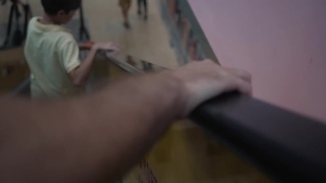Close-up hand on moving escalator in subway