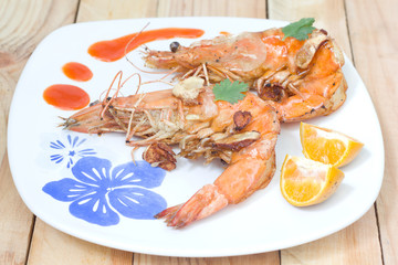 Fried shrimps on the white plate and vegetables.