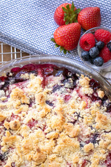 Flat lay of a baked berry cobbler, in a food background with space for text on top