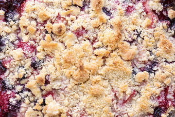 Close up on the crust of a berry cobbler, in a food background