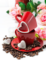 red cups with coffee beans and chocolate candies in the form of heart, vertical