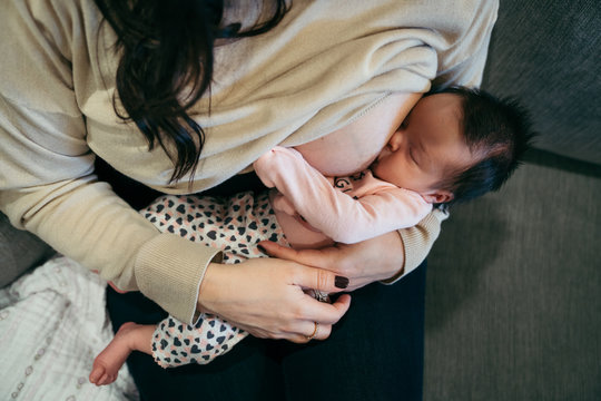Woman breastfeeding her newborn daughter