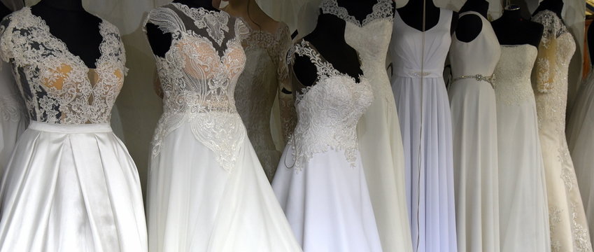 Lange Reihe mit Brautkleidern auf schwarzen Schaufensterpuppen