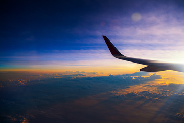 Sunrise sky with wing from window of airplane