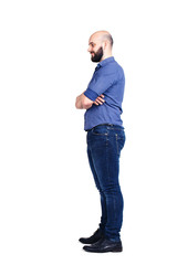 A young bearded guy stands sideways and looking down. Isolated on white.