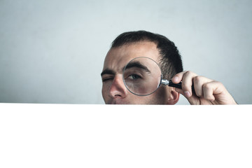  Man looking through magnifying glass. Search and solution. Space for your text