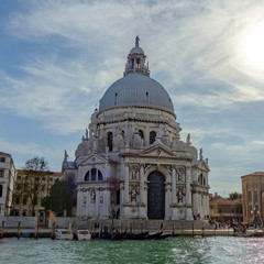 Fototapeta na wymiar Scenic view of Basilica of Santa Maria dela Salute near wide channel (Grand channel) in ancient touristic town Venice in Italy