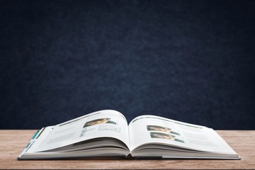 Open book on old wooden table.