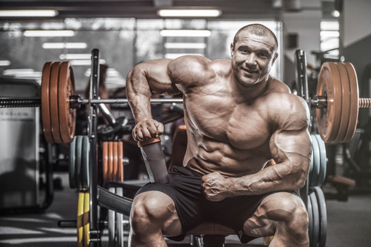 Brutal strong bodybuilder athletic men pumping up muscles with dumbbells