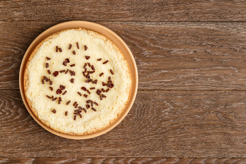 Homemade cheesecake sprinkled with chocolate chips on a wooden background. Top view and copy space