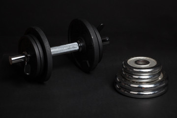 Obraz na płótnie Canvas Dumbbell and barbell discs for workout on black background