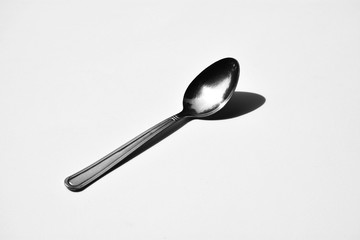silver spoon on pale white background - monochrome
