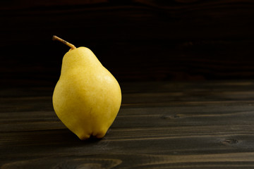 Yellow ripe fresh pear on old wooden board
