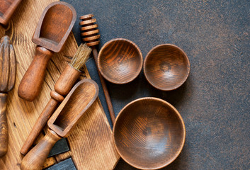Wooden kitchen accessories: plate, rolling pin, board, spatula on a concrete background. Top view. Kitchenware.