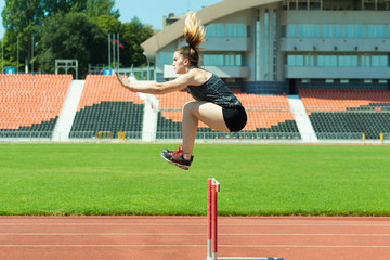 Young girl in the stadium jumping.