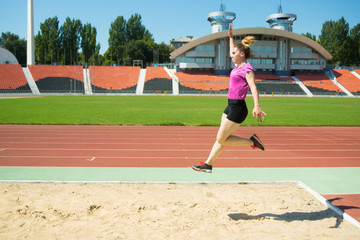 Obraz premium Young girl in the stadium jumping.