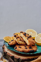 Cranberry cookies on a green ceramic plate handmade on a wooden cut with lemon and slices of dry orange on the background. handmade and craft. close up.