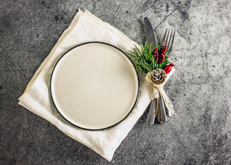 Christmas table setting. White plate, cutlery and Christmas decoration